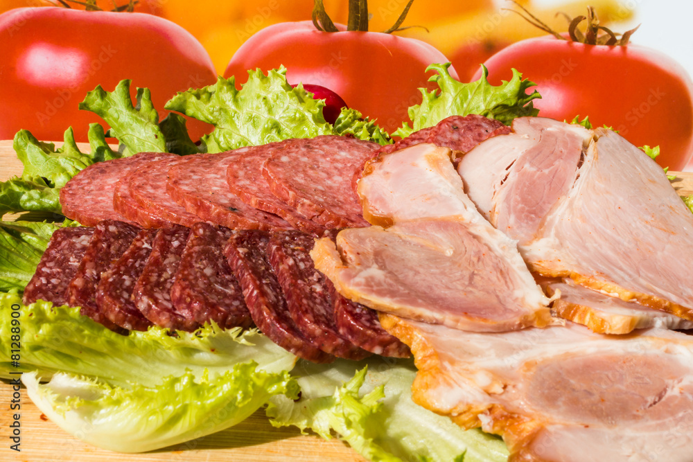 Cut pieces of smoked salam and ham with lettuce