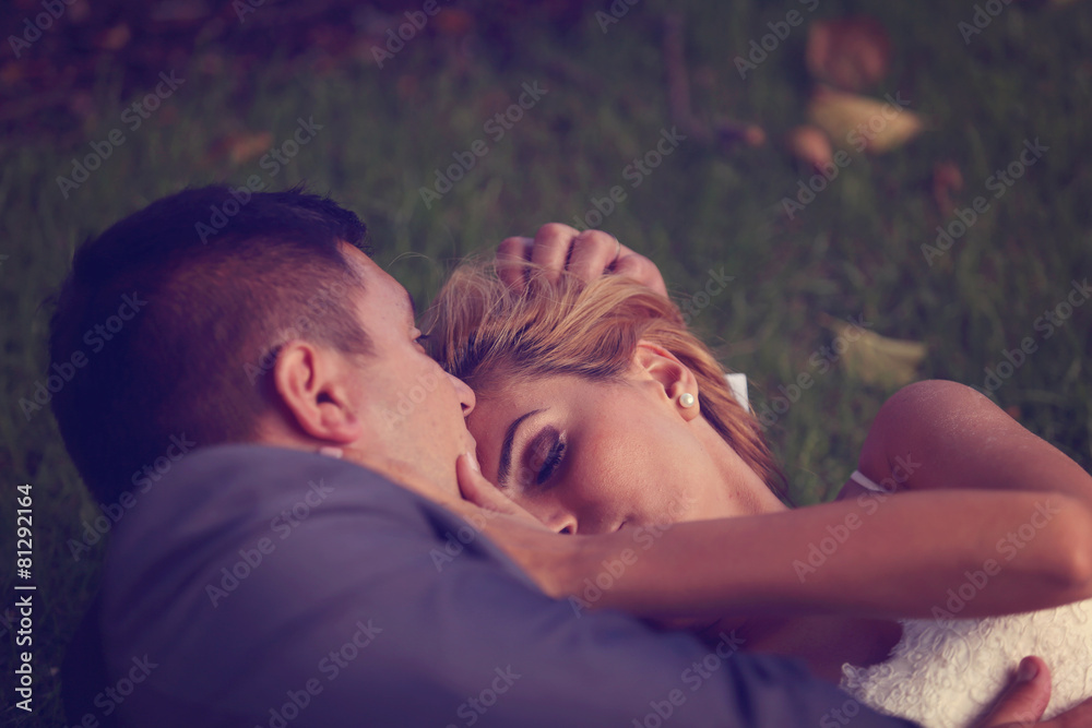 Bride and groom sitting on grass Bride and groom sitting on grass