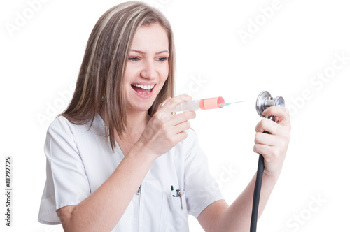 Happy female medic holding syringe and stethoscope