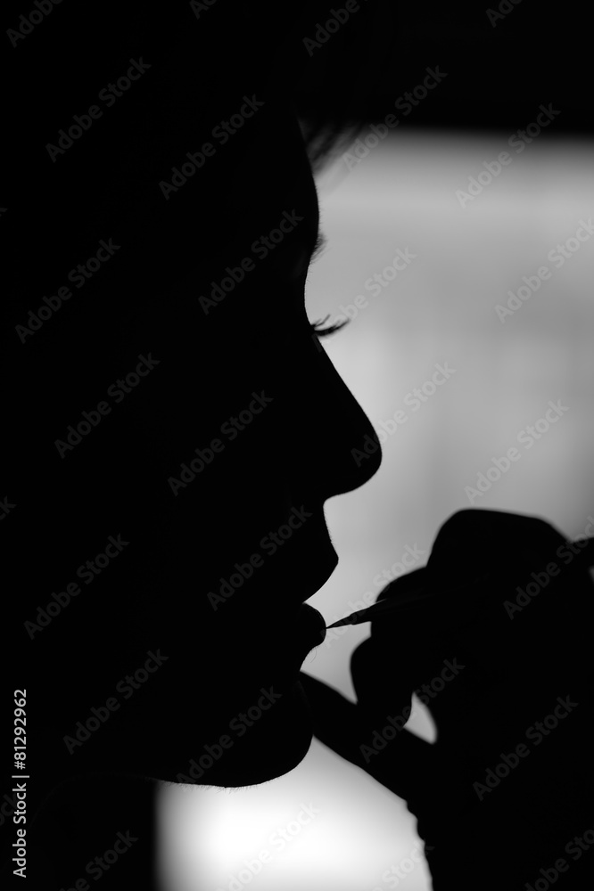 Silhouette of woman at make up artist