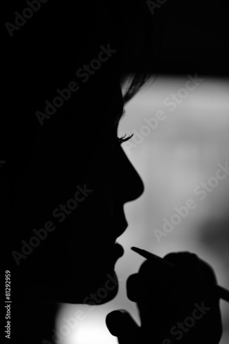 Silhouette of woman at make up artist