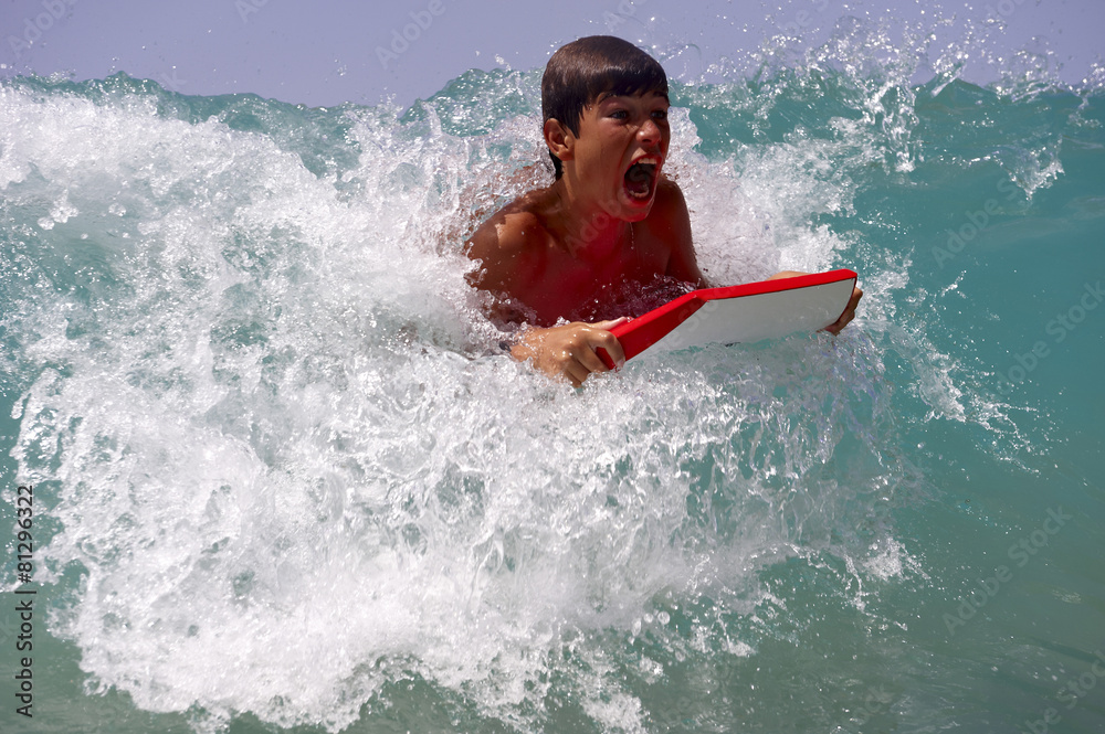 Teenager catching a wave, a surfboard