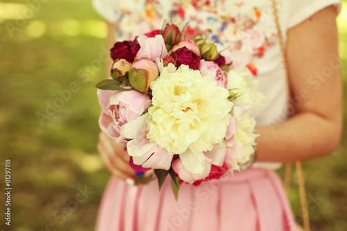 Fototapeta Naklejka Na Ścianę i Meble -  Hands of a woman holding beautiful peonies bouquet