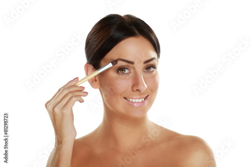 beautiful young woman holding make-up brushes