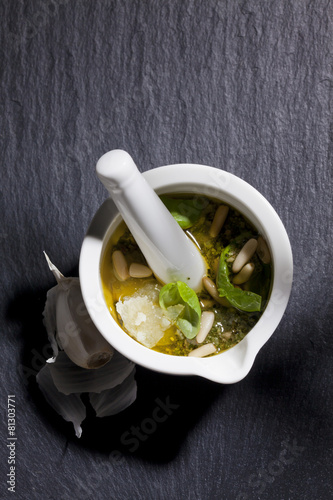 Fotografie Kleiner Mörser mit Pesto, Pinienkerne, Parmesan