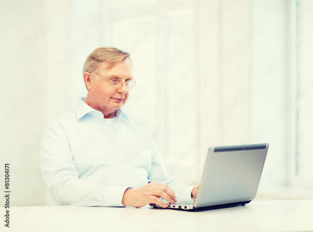 old man in eyeglasses working with laptop at home old man in eyeglasses working with laptop at home
