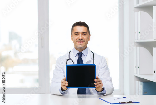 smiling male doctor showing tablet pc blank screen