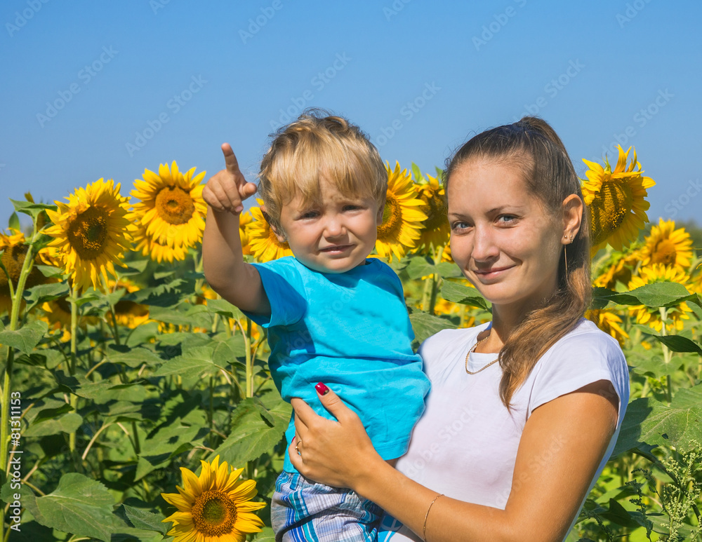 Mum with small son among sunflowers