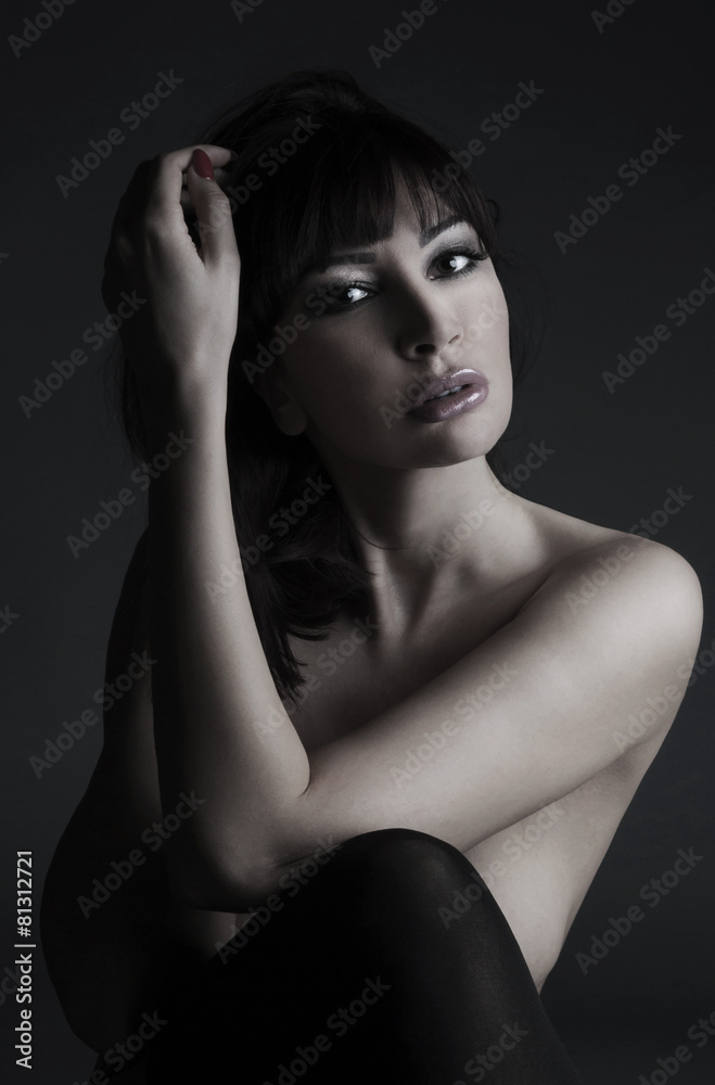 Beautiful naked woman sitting in a studio Beautiful naked woman sitting in a studio