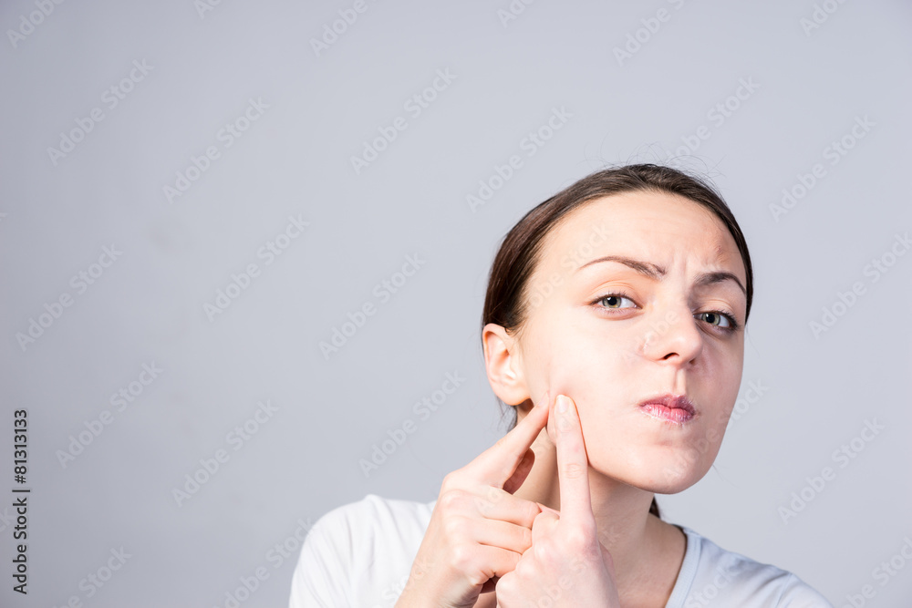 Young Woman Pricking Blackheads on her Cheek Young Woman Pricking Blackheads on her Cheek
