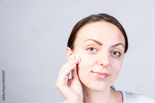 Smiling Woman Scrubbing Face Using Facial Cleanser