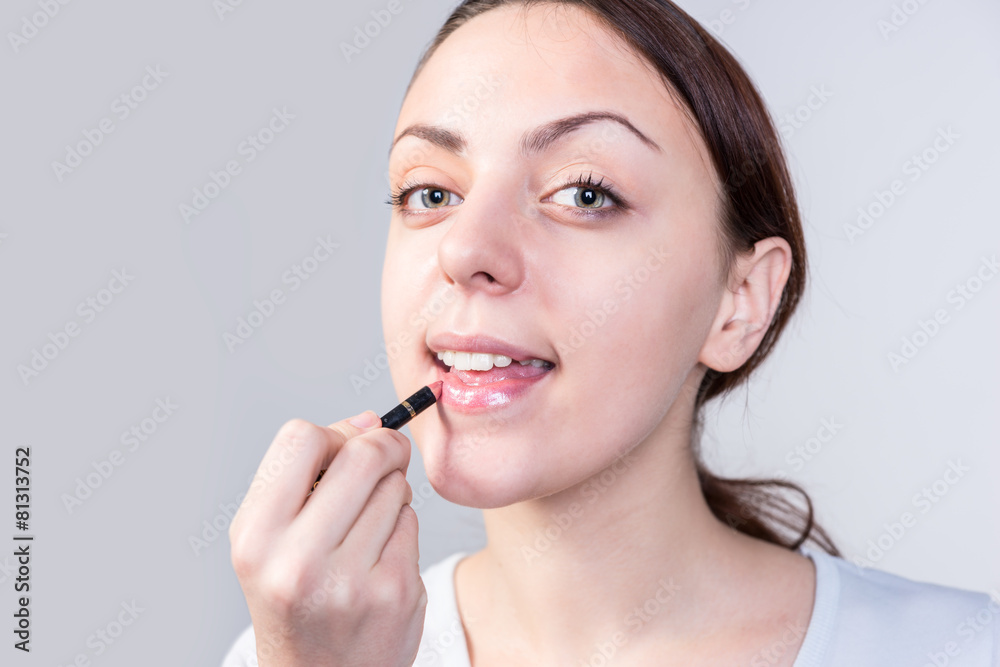 Woman Applying Lipstick While Looking at Camera Woman Applying Lipstick While Looking at Camera
