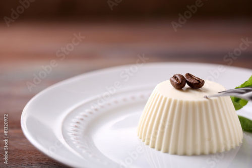 Tasty panna cotta dessert on plate, close up