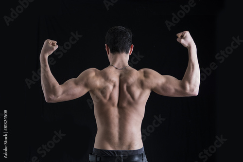 Back of shirtless muscular young man doing double biceps pose