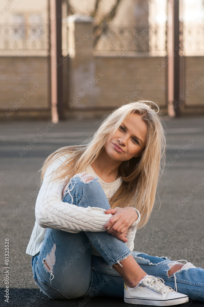 Young pretty fashionable blonde woman dressed in ripped jeans 