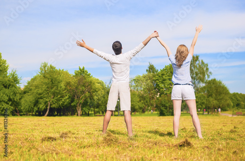 Young Caucasian Couple Standing Together on Grass Meadow with ha