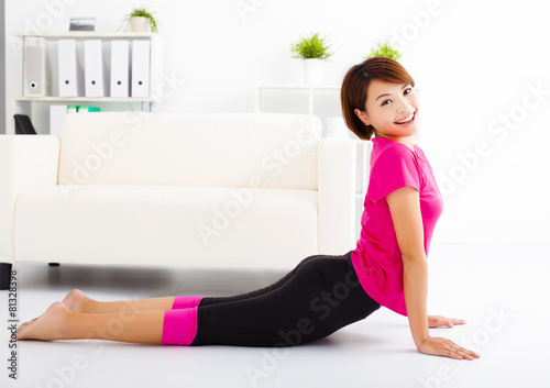 beautiful young woman stretching on the floor