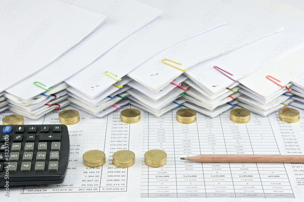 Brown pencil with black calculator between Pile of gold coins Brown pencil with black calculator between Pile of gold coins