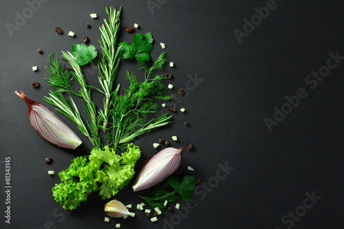 Black food background with fresh aromatic herbs and spices, view