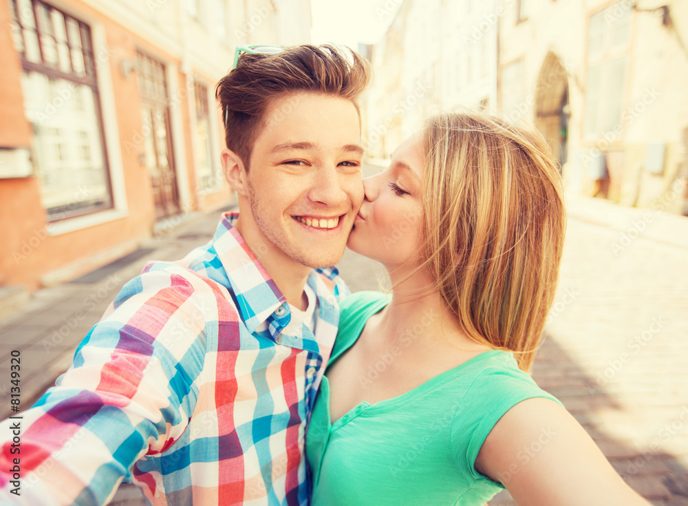 smiling couple with smartphone in city