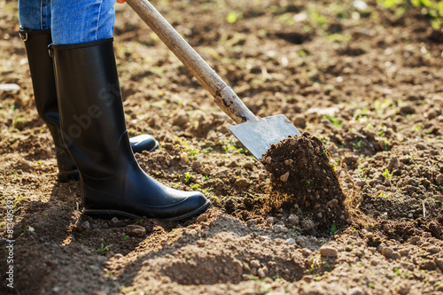 Boot shoveling ground in the garden