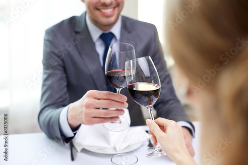 happy couple with glasses of wine at restaurant