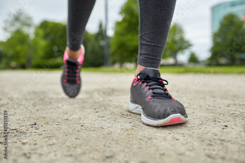 close up of woman feet running on track from back