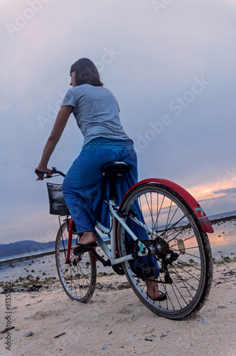 Woman whith bicycle on the beach