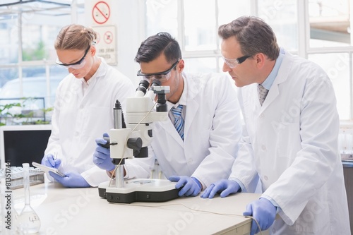 Scientists examining something with the microscope