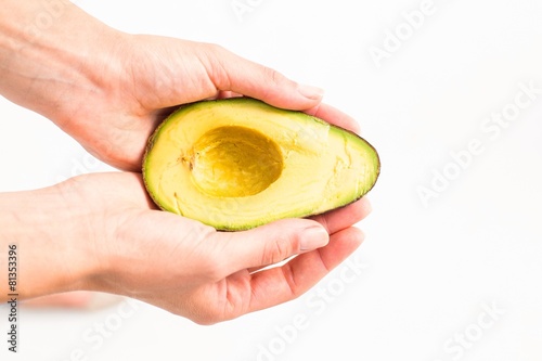 Woman presenting half of an avocado