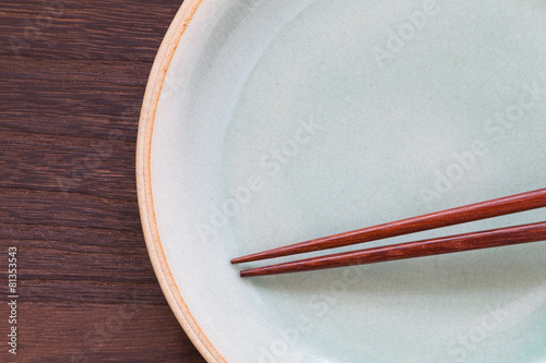 Wood brown chopsticks and celadon ceramic on wood table