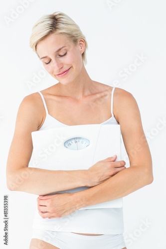 Happy woman holding scales