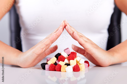 Female hands over a pyramid of candies
