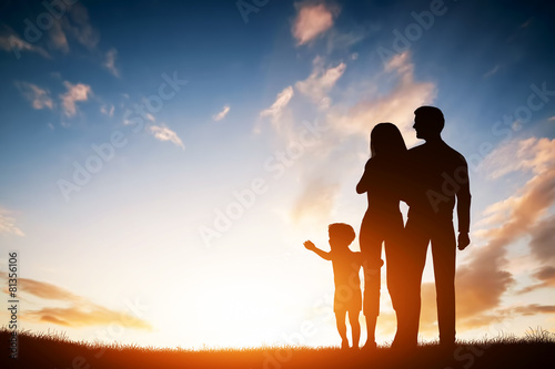 Happy family together, parents with their child at sunset.