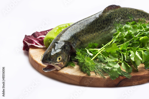 Fresh trout on wood cutting board on on white background