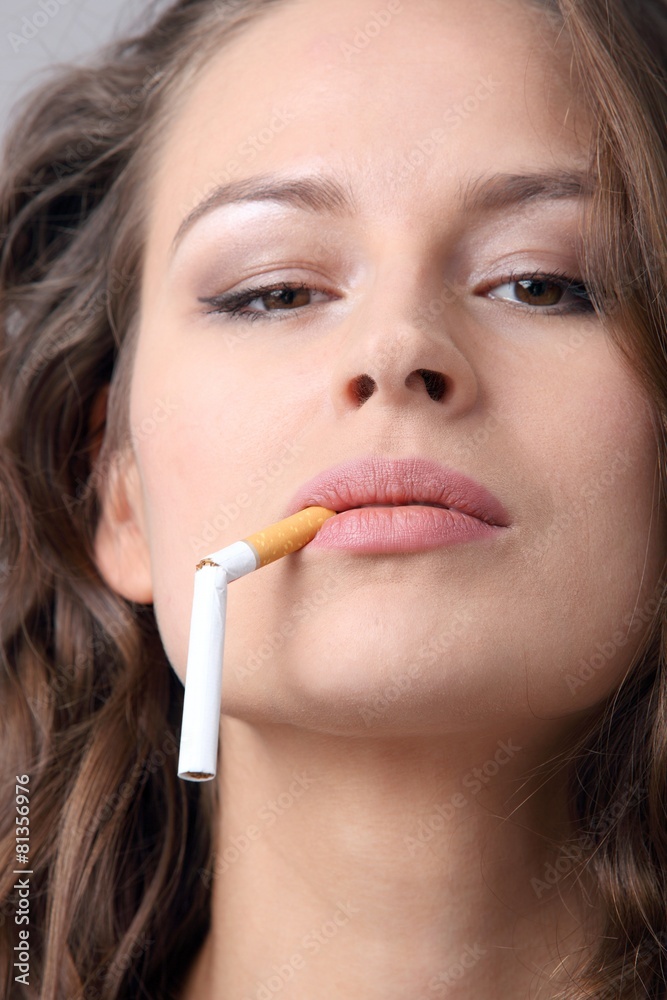 Frau mit durchgebrochener Zigarette im Mund