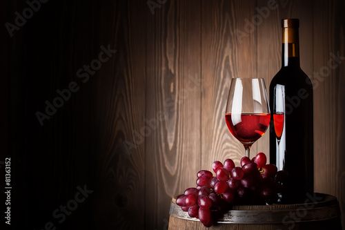 Bottle and glass of red wine with grapes