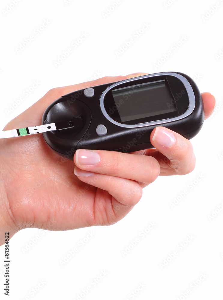 Closeup of strip for glucose testing and glucose meter Closeup of strip for glucose testing and glucose meter