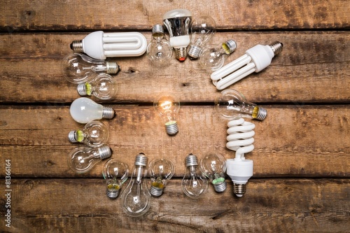 Leadership. Glowing bulb uniqueness concept on brown wooden