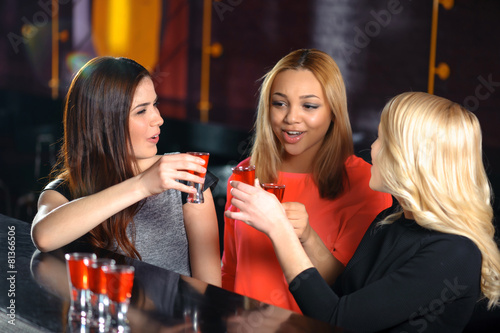 Three women have a drink in the bar