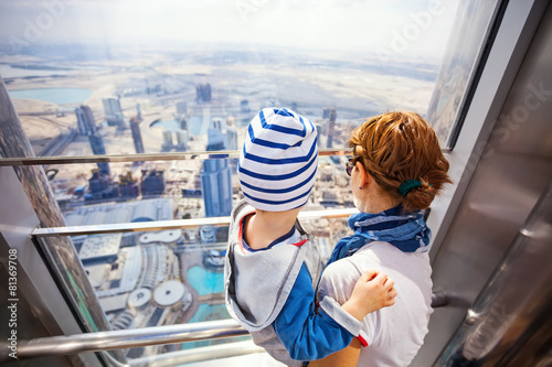 Young woman and son looking out of window from Burj Khalifa