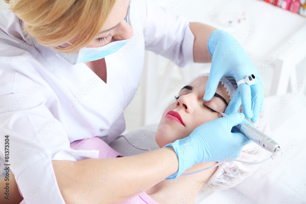 Cosmetologist applying permanent make up on eyes, close-up Cosmetologist applying permanent make up on eyes, close-up