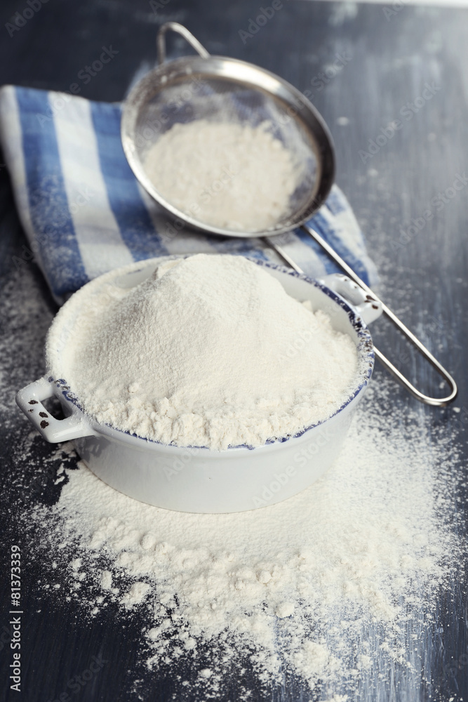 Sifting flour through sieve on wooden table, closeup Sifting flour through sieve on wooden table, closeup