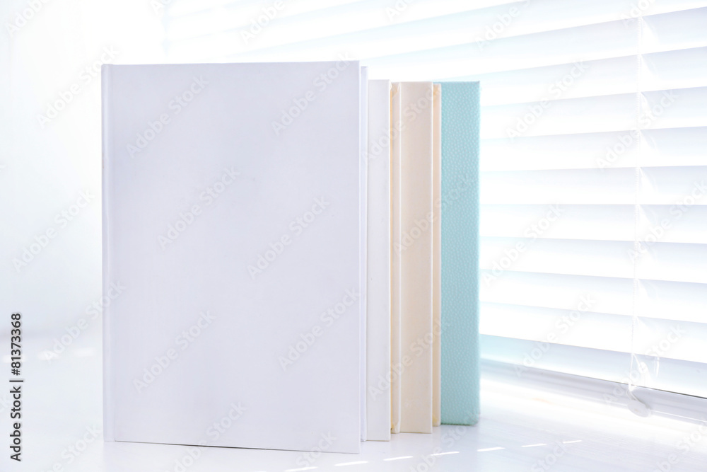 Naklejka premium Books on white windowsill, close up