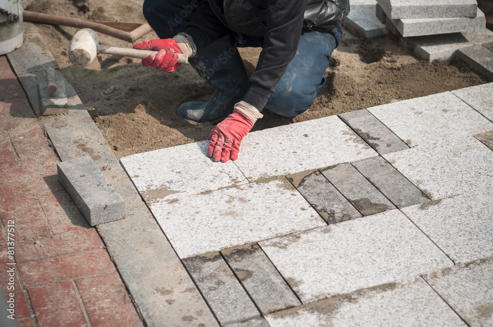 Construction worker installing the pavestone Construction worker installing the pavestone