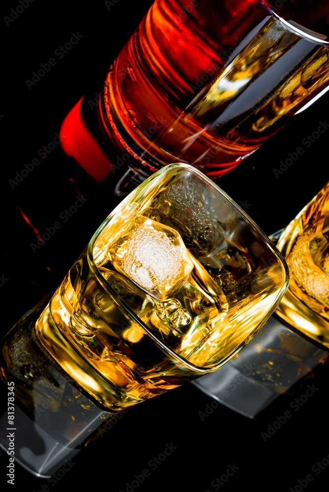top of view of whiskey with ice in two glasses on black top of view of whiskey with ice in two glasses on black