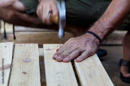 man hand working on wood with a hammer -serial-
