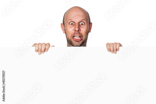 A funny silly shocked man holding a white sign and pulling a face. Isolated on white.