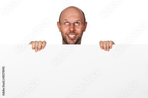A funny silly happy man holding a white sign and pulling a face. Isolated on white.