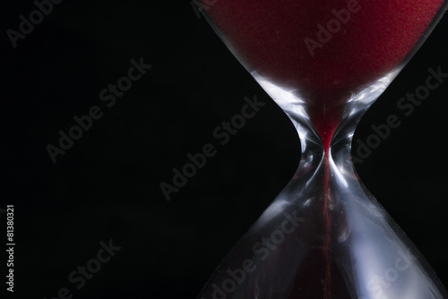 Close up of red hourglass on black background